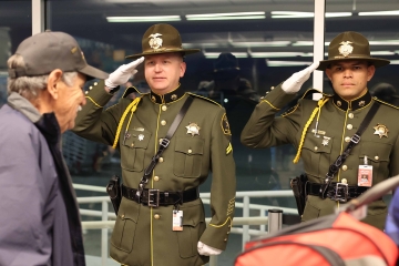 Honor Guard saluting veterans at the airport