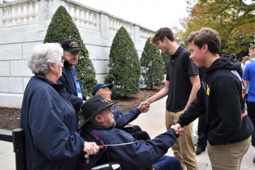 Student shaking hands with veterans