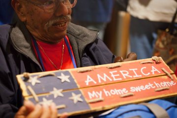 Veteran with America My Home Sweet Home sign