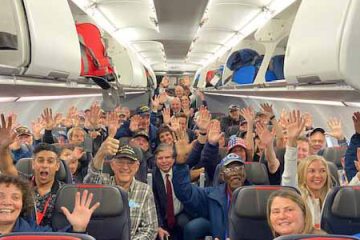 Group waving from inside the plane